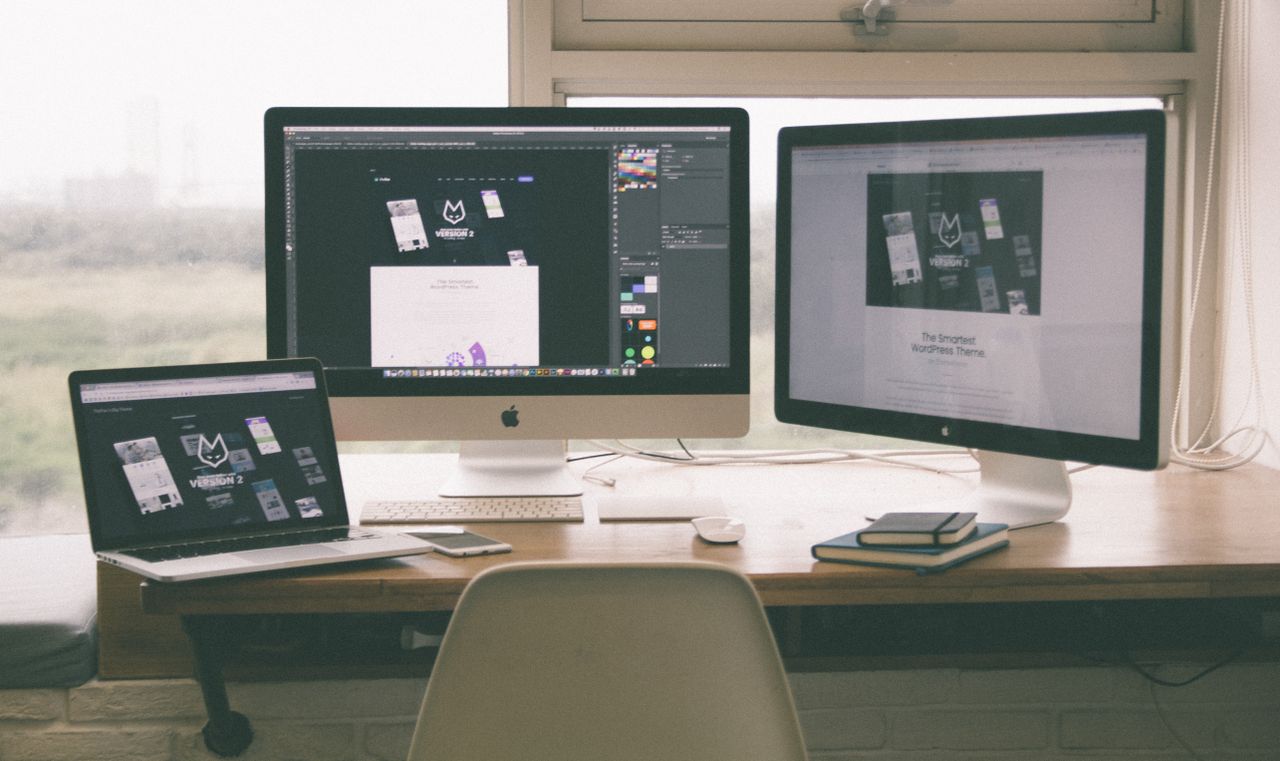 gallery-01 Stylish and efficient workspace with multiple monitors, laptop, and smartphone, showcasing a web design project.